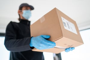 man delivering package with gloves and mask during COVID